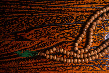 Obraz premium close up of wood tasbih with blur bokeh on wooden background. Wooden rosary