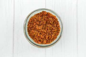 Sponge cake with cream in a jar on a white wooden background