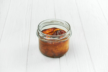 Basque cheesecake in a jar on a white wooden background