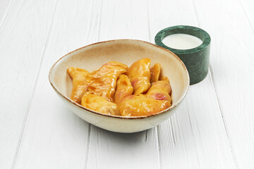 Sweet vareniki with cherries and sour cream in a plate on a white wooden background. dumplings