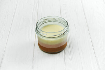 Dessert three milks in a jar on a white wooden background