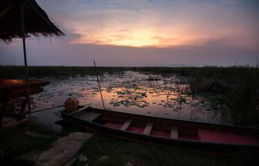 Sunset on the lake with wooden boat