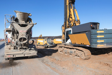 Powerful hydraulic drilling rig at a construction site and vehicle mixer for concrete delivery. The device of pile foundations. Bored piles. heavy construction equipment.