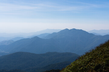 Obraz premium Mountain range layer with faded fog.