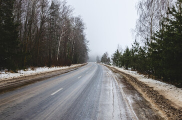 Fototapeta premium The road stretching into the distance in winter in cloudy weather