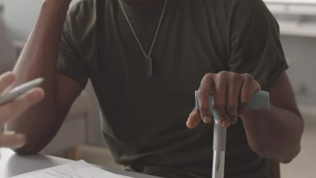 Medium closeup of upset African American veteran soldier suffering from depression and psychological trauma sharing concerns and flashbacks from war with professional military psychologist