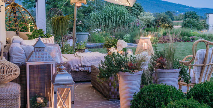 Taras miejscem wypoczynku i relaksu w ogrodzie wieczorna porą. Pięknie udekorowany taras ogrodowy