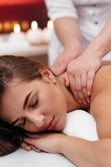Fototapeta na wymiar Professional masseur doing therapeutic massage. Woman enjoying massage in her home. Young woman getting relaxing body massage.