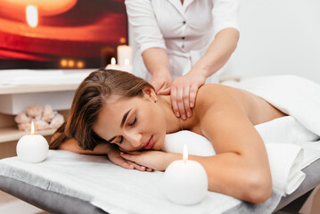Fototapeta na wymiar Spa woman. Female enjoying relaxing back massage in cosmetology spa centre. Body care, skin care, wellness, wellbeing, beauty treatment concept.