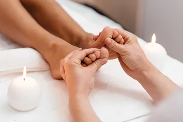 Fotobehang Woman enjoyingreflexology foot massage in wellness spa © fotofrol
