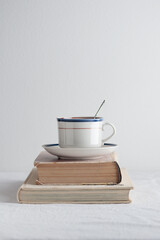Cup with old books on the table