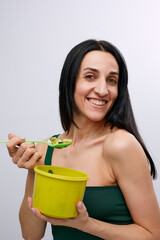 Young model healthy woman eating green vegetables avocado, cucumber and green herbs. Detoxification, vegetarian, healthy eating and diet concept