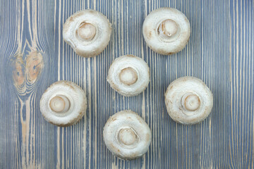Champignon mushrooms on a wooden table.