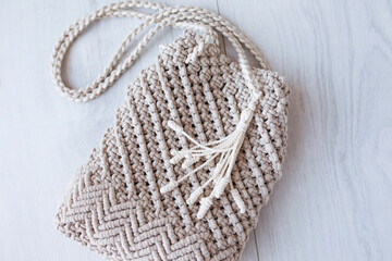 Handmade macrame bag. ECO friendly natural macrame cotton cross-body bag. Hobby knitting handmade macrame. Modern summer concept. Close up.