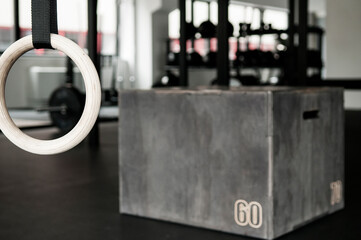 Gymnastics ring in focus with box and functional training gym interior in background
