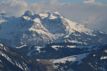 Snow covered peaks of the Swiss Alps on a cloudy morning.