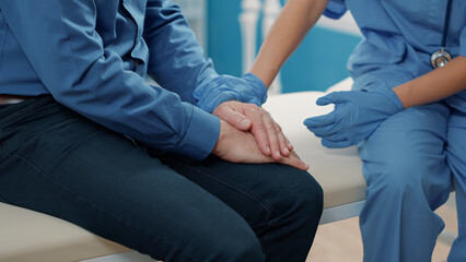 Medical assistant comforting senior patient to help with recovery, showing compassion after finding...