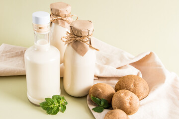 three glass bottles with vegan vegetable milk from potato tubers on a beige pastel background. the concept of healthy eating. drink substitute.