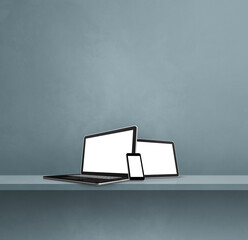 Laptop, mobile phone and digital tablet pc on grey wall shelf. Square background