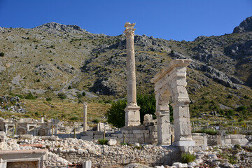Fototapeta na wymiar arch and column of ancient town sagalassos on mountain background, Turkey