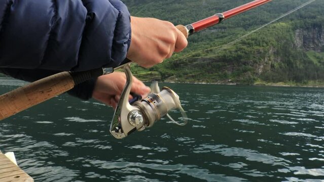 Woman fishing on Fishing rod spinning in Norway.