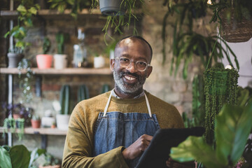 Plant shop owner using a digital tablet in store