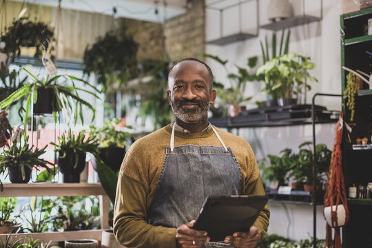 Portrait of a plant shop owner using a digital tablet in store