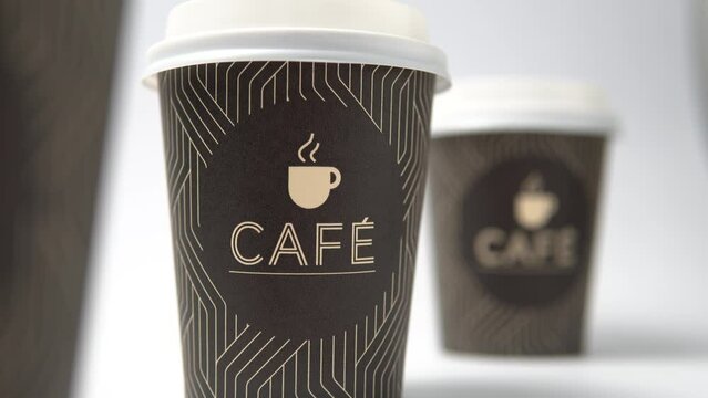 Forward motion picture of 3 brown portable coffee cups. Video of three cups of takeaway coffee slowly zooming in on the image.