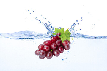 Red grapes falling in blue clear wave water splash isolated on white background. © NIKCOA