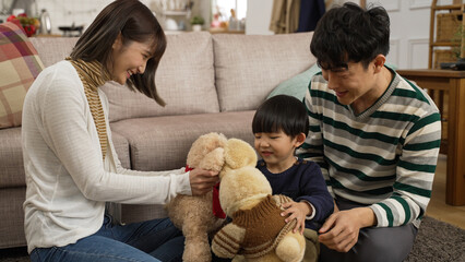 asian father and mother playing with their cute baby son with toy animals in the living room at...