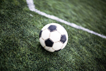 Obraz premium Soccer ball on grass. Football field background. Green lawn for playing football. Outdoor sport for health. Kick the ball soccer match.