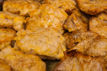 Grilled meat chops in egg batter close-up.