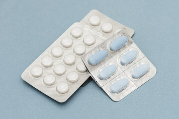 Colorful of tablets and capsules pill in blister packaging arranged on the blue background.