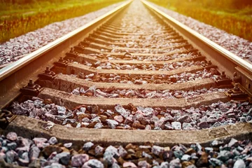 Fototapete Rund Railway track line in sunlight, railroad train track landscape with ballast gravel and crushed stone © TRAVELARIUM