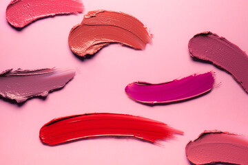 Red pink orange lipstick isolated on pink background texture smudged