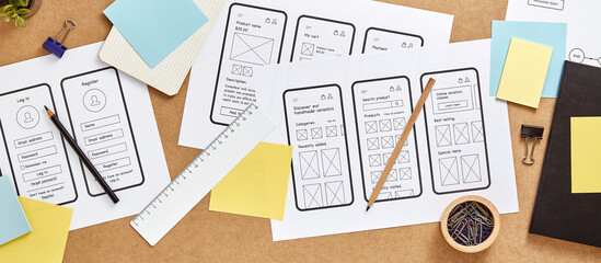 Responsive web design concept banner. Web UX designer busy desk with numerous mobile app wireframe...