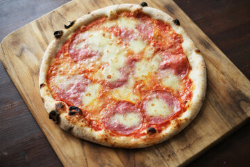 Fresh pizza with tomatoes, cheese and mushrooms on wooden table closeup
