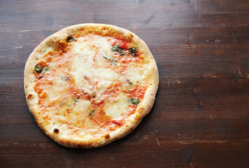Fresh pizza with tomatoes, cheese and mushrooms on wooden table closeup
