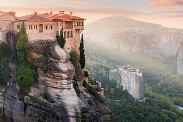 Monastery of Varlaam and Saint Barbara Rousanos building on top of a sandstone rock with ray of light at sunrise. Must-visit iconic travel and pilgrimage destinations of the World - obrazy, fototapety, plakaty