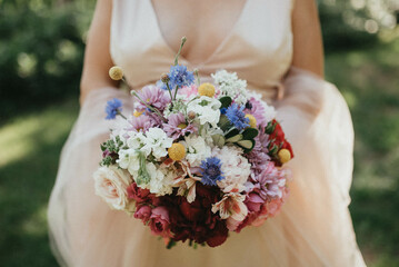 Bride holding a wedding bouquet. Rustic wedding bouquet.