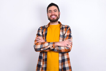 young caucasian man wearing plaid shirt over white background being happy smiling and crossed arms looking confident at the camera. Positive and confident person.
