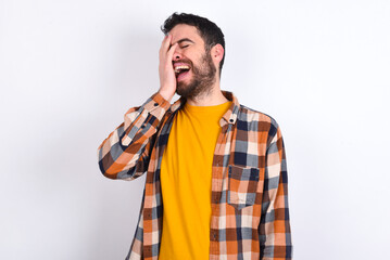Charismatic carefree joyful young caucasian man wearing plaid shirt over white background likes...