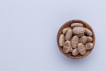 Alternative medicine tablets on a wooden spoon.