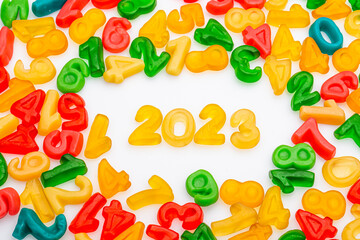 New Year 2023 candy background. Colorful lollipops and different colored round candy. top view.
