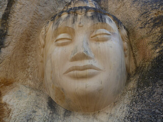 Buddha sculpture carved into the rock of a mountain