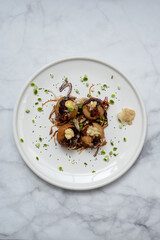 A plate of takoyaki over a marble table