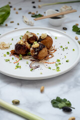 A plate of takoyaki over a marble table