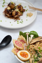 A bowl of Ramen soup an a plate of Takoyaki snack