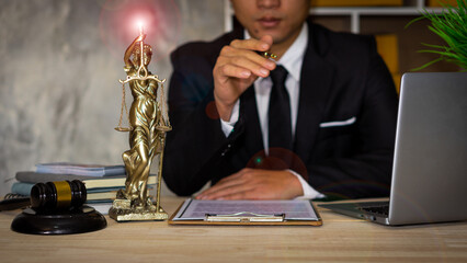 Attorney's office works on justice. businessman in suit or lawyer working on paperwork Legal concepts, advice, and justice, a judge with a hammer and scales, a laptop god.