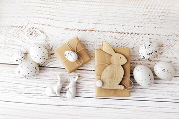 spring decoration with easter gift boxes, eggs and bunny on white wooden background